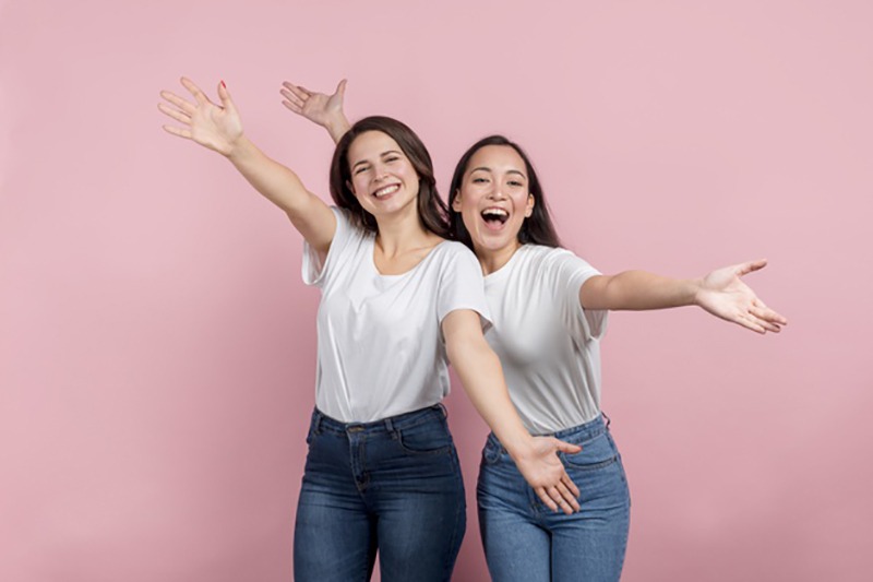 Duas mulheres felizes de braços abertos