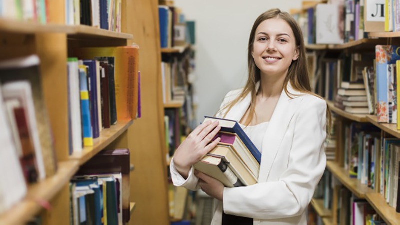 Garota carregando livros para estudo